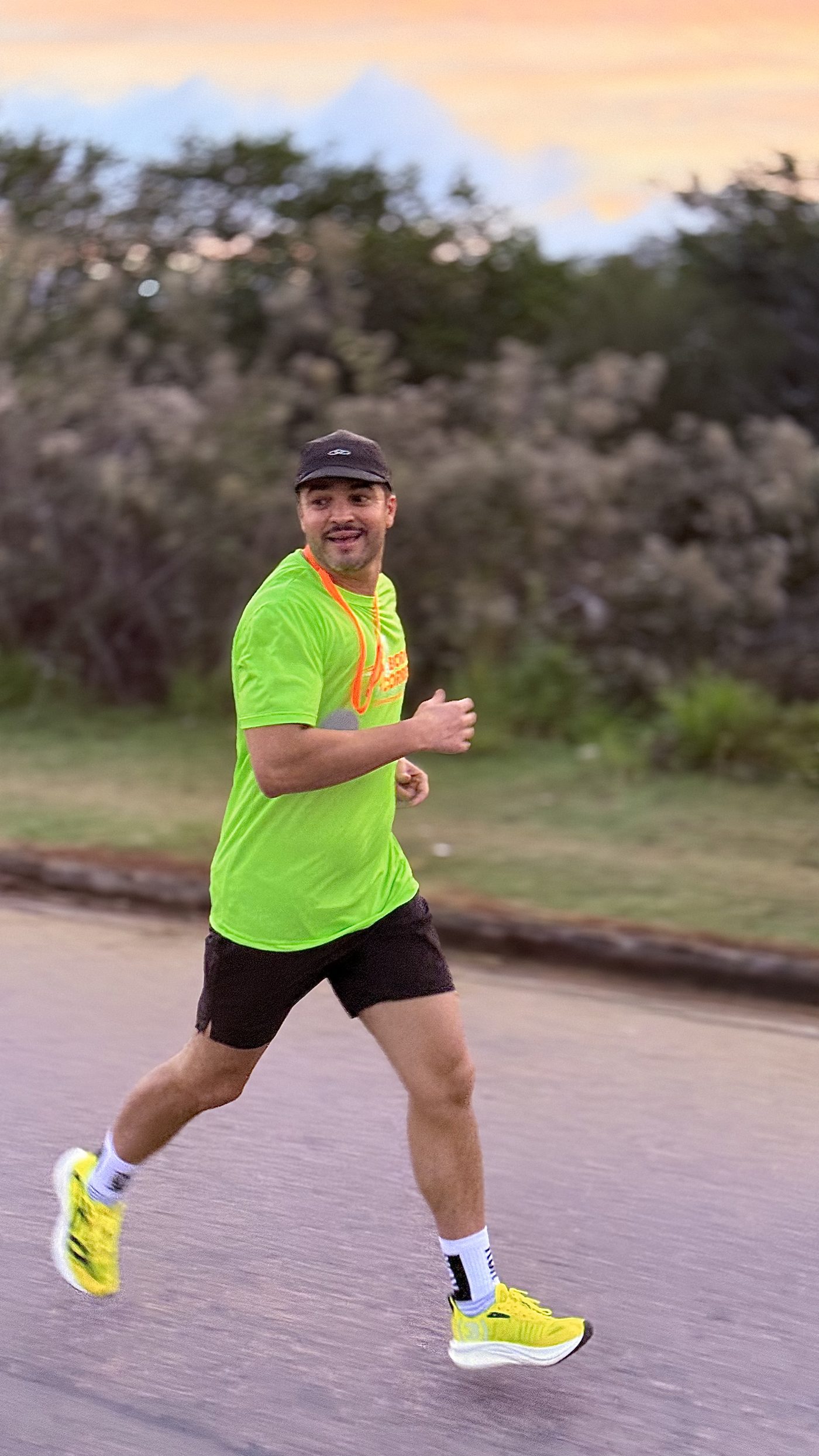 Corredor sorrindo com a medalha, ao pôr do sol em Jundiaí