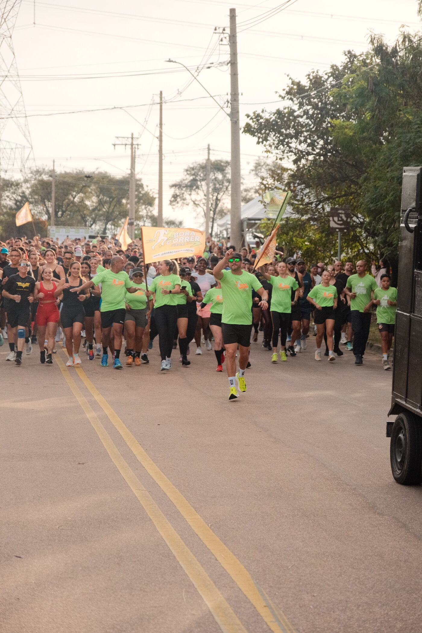 Pelotão de corredores descendo a avenida durante o treinão